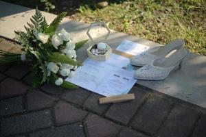 invitación de boda, anillos de boda, zapatos de boda y flores foto