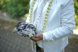 novio en vestido de novia blanco con tocado tradicional foto