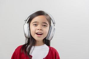 Lttle girl Asia cute enjoying her music headphones photo