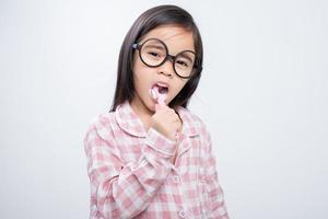 little girl Asia brushing teeth happily white background photo