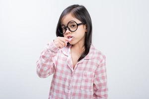 little girl Asia brushing teeth happily white background photo
