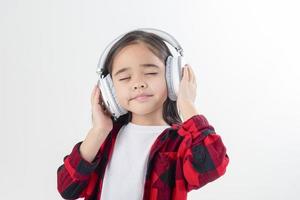 pequeña niña asia linda disfrutando de sus auriculares de música foto