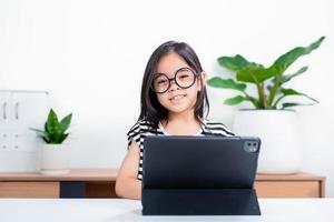 Asian child girl student wow excited on video call learning to studying online class or person learn from home school with tablet photo