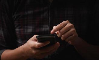 man's hand using a mobile phone browsing mobile device apps, reading news, chatting or shopping online, searching information in internet, holding smartphone, internet business, digital marketing photo