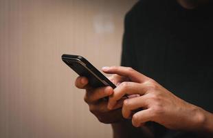 man's hand using a mobile phone browsing mobile device apps, reading news, chatting or shopping online, searching information in internet, holding smartphone, internet business, digital marketing photo