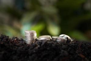pile of silver coins with green nature background. money saving and business finance concept, business growth and money future, financial success photo