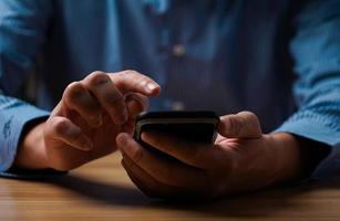 man's hand using a mobile phone browsing mobile device apps, reading news, chatting or shopping online, searching information in internet, holding smartphone, internet business, digital marketing photo