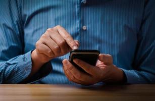 man's hand using a mobile phone browsing mobile device apps, reading news, chatting or shopping online, searching information in internet, holding smartphone, internet business, digital marketing photo