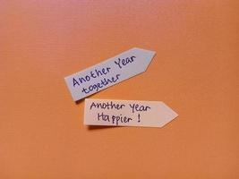 Greeting text written on notes stick and isolated on orange background photo