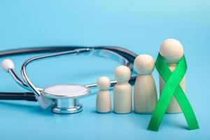 Green ribbon and stethoscope.treatment concept for ovarian cancer and cervical cancer. photo