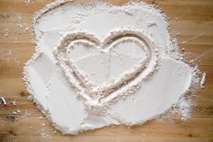 Valentine's Day. Heart symbol of love, drawn on flour, on a wooden texture. Copy space. Conceptual. photo