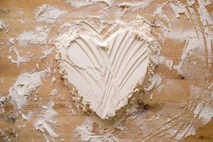 Valentine's Day. Heart symbol of love, made of flour on a wooden texture. Copy space. Conceptual. photo