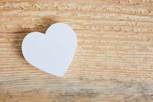 White heart on a wooden background.Love for environmentally friendly materials and work with wood. photo