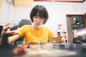 Young adult asian woman enjoying role playing tabletop and board games photo