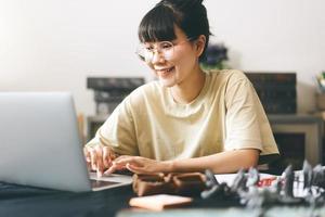 Asian woman using laptop for half role playing tabletop and board game with online friends photo