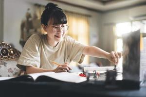 mujer asiática adulta joven que disfruta de juegos de rol narración de cuentos de mesa y juego de mesa con miniaturas foto