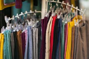 Clothes that are arranged on shelves and hangers photo