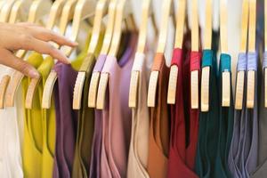 Clothes that are arranged on shelves and hangers photo