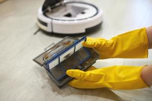 Robot vacuum cleaner, taking out filter, cleaning. Close up. photo