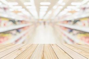 Wood table top with supermarket grocery store aisle interior blurred background with bokeh light for product display photo