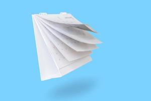 White paper desk calendar flipping page isolated on blue background photo