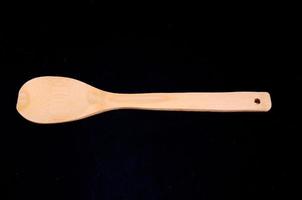 Wooden spoon on black background photo