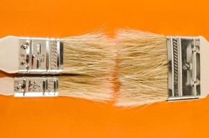 Paint brushes on orange background photo