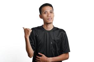 excited asian man wearing black training t-shirt, pointing to copy space. Isolated by white background photo