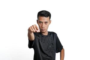 Asian man wearing black training t-shirt, gesturing to fight. Isolated by white background photo