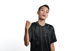 asian man wearing black training t-shirt, showing a strong stance with raised arms and muscles. Isolated by white background photo