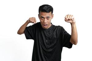 Asian man wearing black training t-shirt, gesturing to fight. Isolated by white background photo