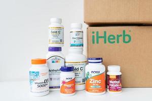 Lviv, Ukraine - December 17, 2022 Unboxing boh delivered from iherb online store. Package with vitamins and supplements to support health. photo