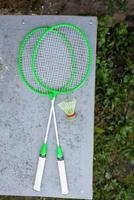 Green badminton rackets on the table. Outdoor sports, active recreation. View from above. Sports equipment. photo