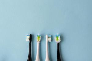 Modern electric toothbrush on a blue background, it's time to change the brush - old and new brush attachment. Hygiene concept for daily oral care. photo