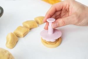 The process of making cookies with shapes in the form of flowers, a rolling pin and a tray, the concept of cooking, baking at home. photo