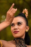 Portrait of a Balinese woman with beautiful makeup and tied black hair on a brave facial expression photo