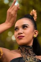 Portrait of a Balinese woman with beautiful makeup and tied black hair on a brave facial expression photo