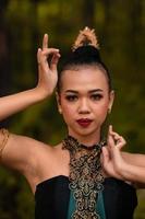 Brave Face of an Asian woman in a traditional green costume with golden accessories on her body during the competition in a dance festival photo