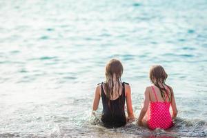 Adorable little girls have a lot of fun on the beach. photo