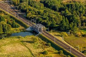 aerial panoramic view on steel frame construction of huge train railway bridge across river photo