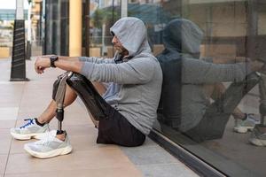 Handicapped sportsman sitting near glass wall photo