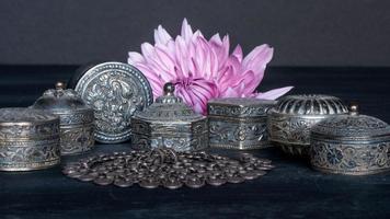 Closeup arrangement of traditional Omani silver pill boxes and a necklace. photo