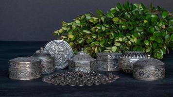 una colección de plata omaní sobre un fondo oscuro con una ramita de vegetación. foto
