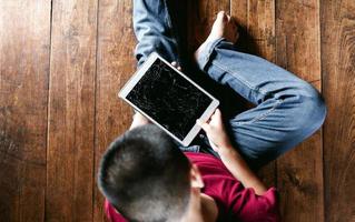 Portrait of a little Asian boy, Kid sad face, Unhappy child sitting holding  broken tablet computer, Emotion sad and sad face, depressed children concept photo