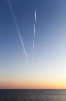 el cielo con un avión volador al atardecer foto