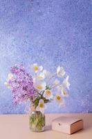 Lilac and anemones flower bouquet with gift box. Spring, Mother's Day or March 8 greeting concept. photo