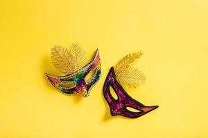 Festive face masks for carnival celebration on colored banner background flat lay, top view photo