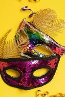 Festive face mask for carnival celebration or masquerade on colored background photo