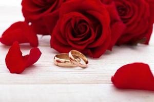 anillos de boda y ramo de novia de pétalos de rosas rojas. foto