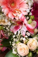 Wedding rings and many colorful flowers with roses bouquet photo